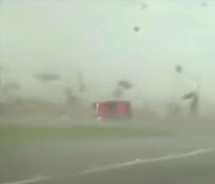 Picture of a red pick up being tipped over in a tornado